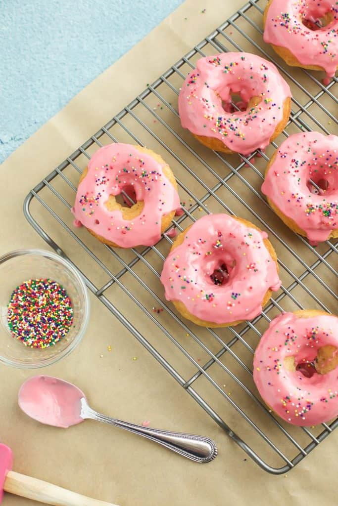 vanilla Donuts with Raspberry Glaze on a cooling rack