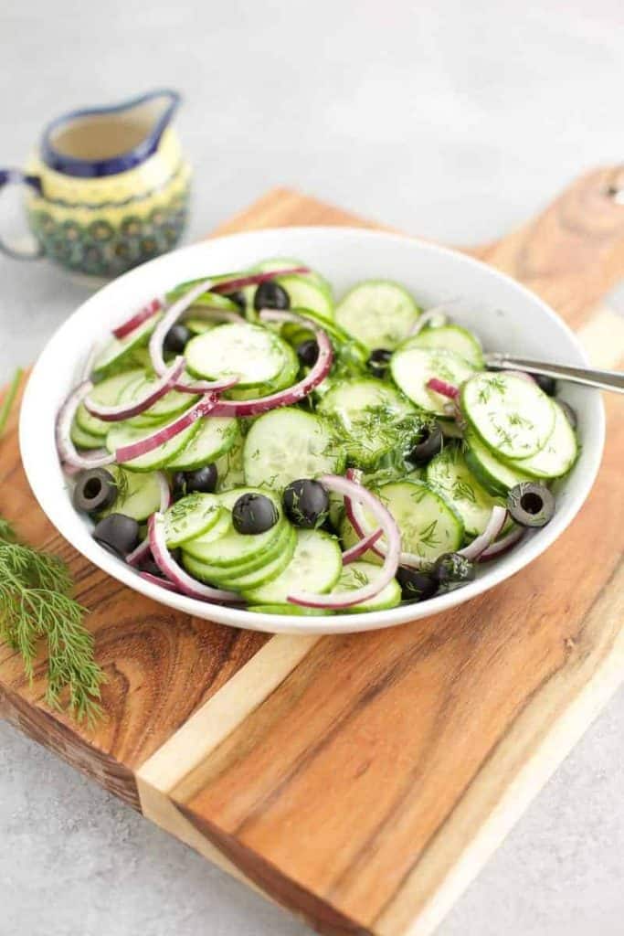 Cucumber Salad Keto in a white bowl on a cutting board