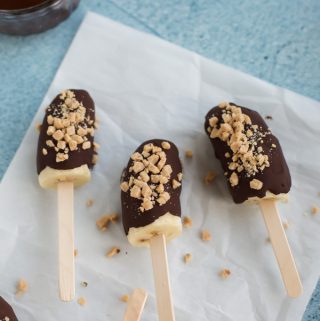 chocolate covered frozen bananas on a stick