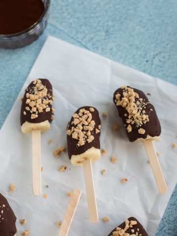 chocolate covered frozen bananas on a stick