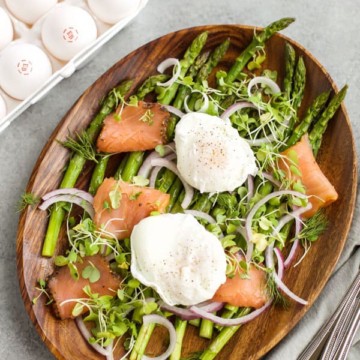 Roasted asparagus salad with poached eggs, featuring smoked salmon.