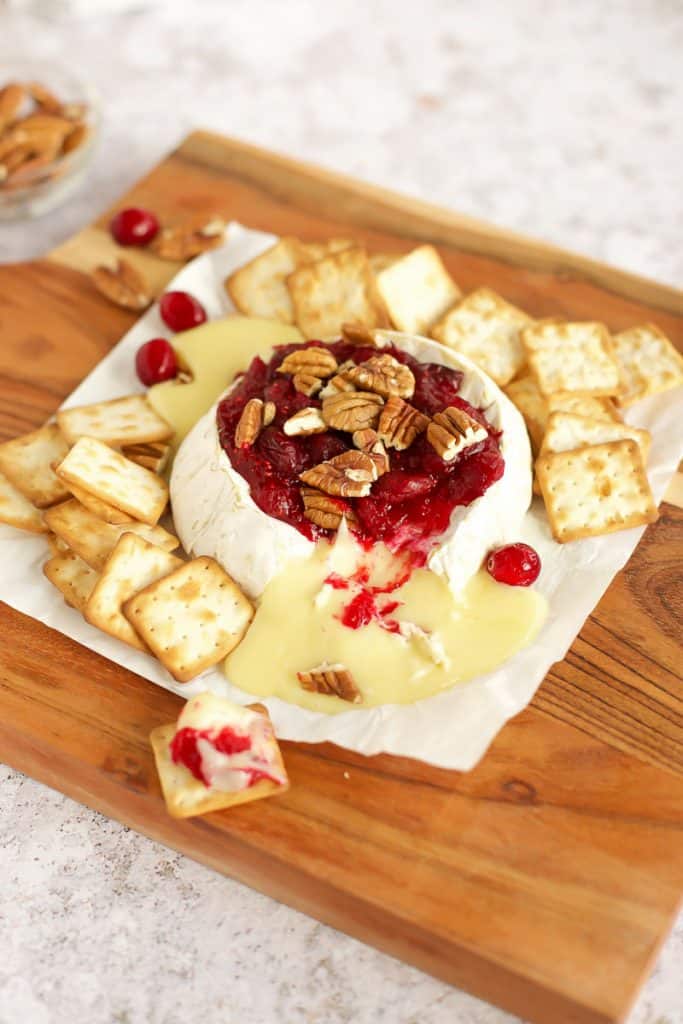 Baked Brie on a wooden board.