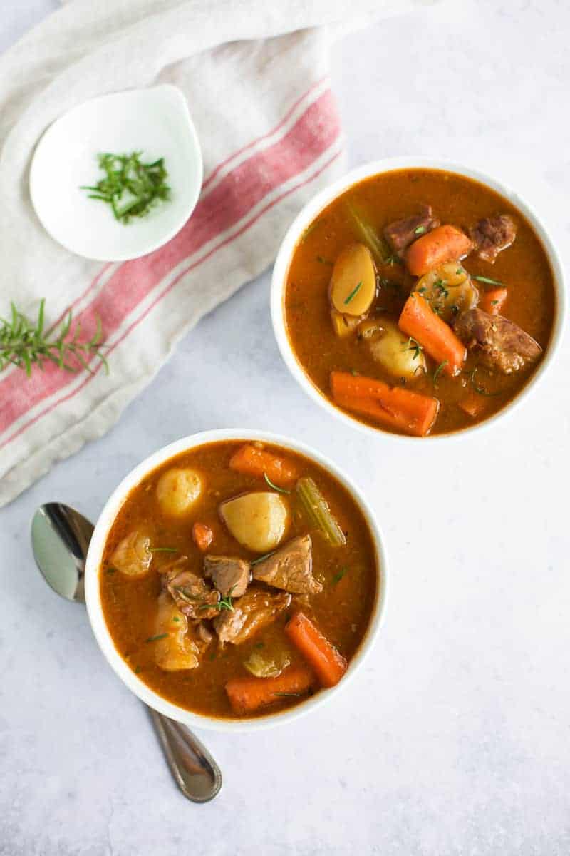 Two bowls of gluten-free instant pot beef stew with carrots and potatoes.