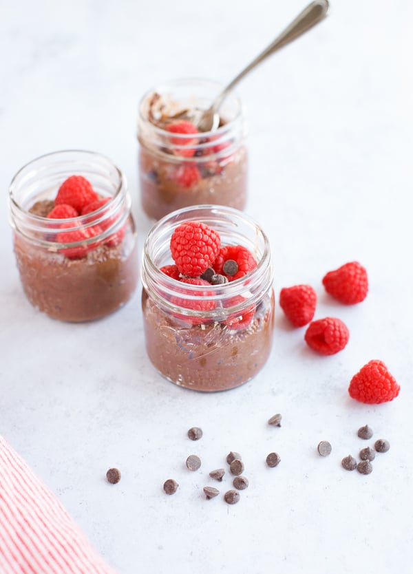 whole30 chia pudding with raspberries in three jars