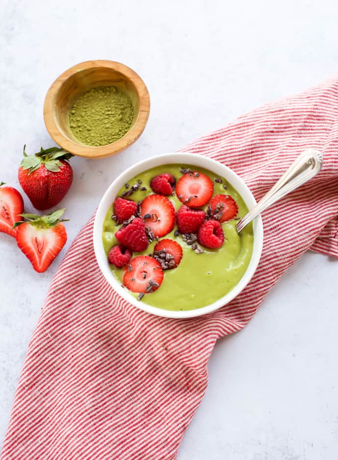 matcha green tea smoothie with strawberries on the side