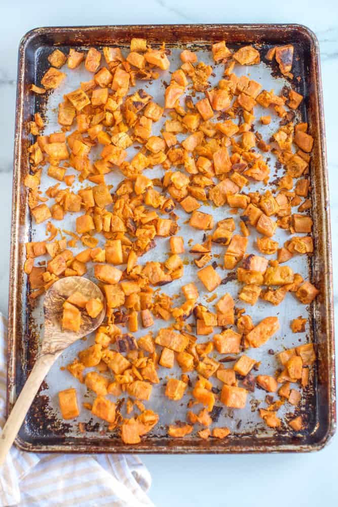 seasoned roasted sweet potatoes on a sheet pan