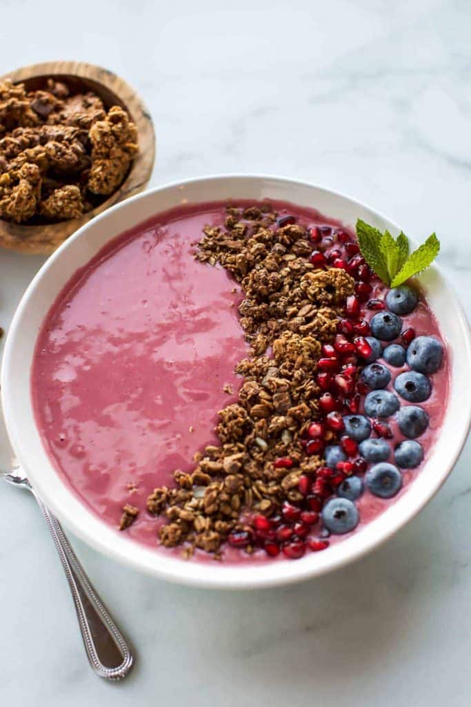 raspberry smoothie bowl with granola and blueberries
