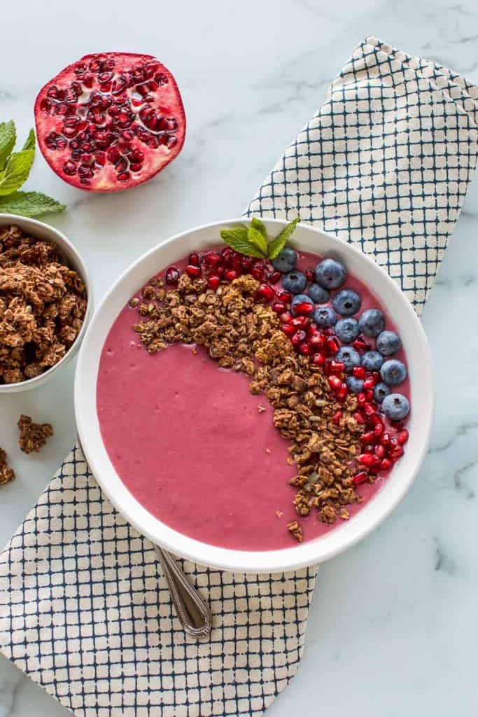 smoothie bowl with lots of toppings in a white bowl
