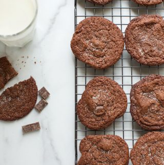 Gluten Free Chocolate cookies on a cooling rack with a glass of milk.