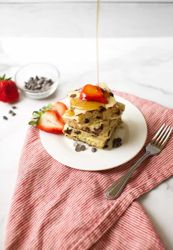 pancakes with strawberries and syrup dripping down on them