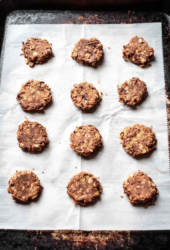 gluten free oatmeal cookies on a sheet pan with parchment paper