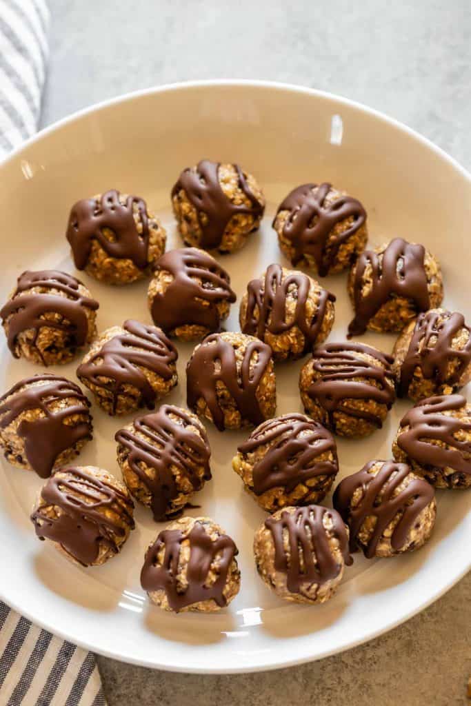 snack balls with chocolate drizzle on a white plate