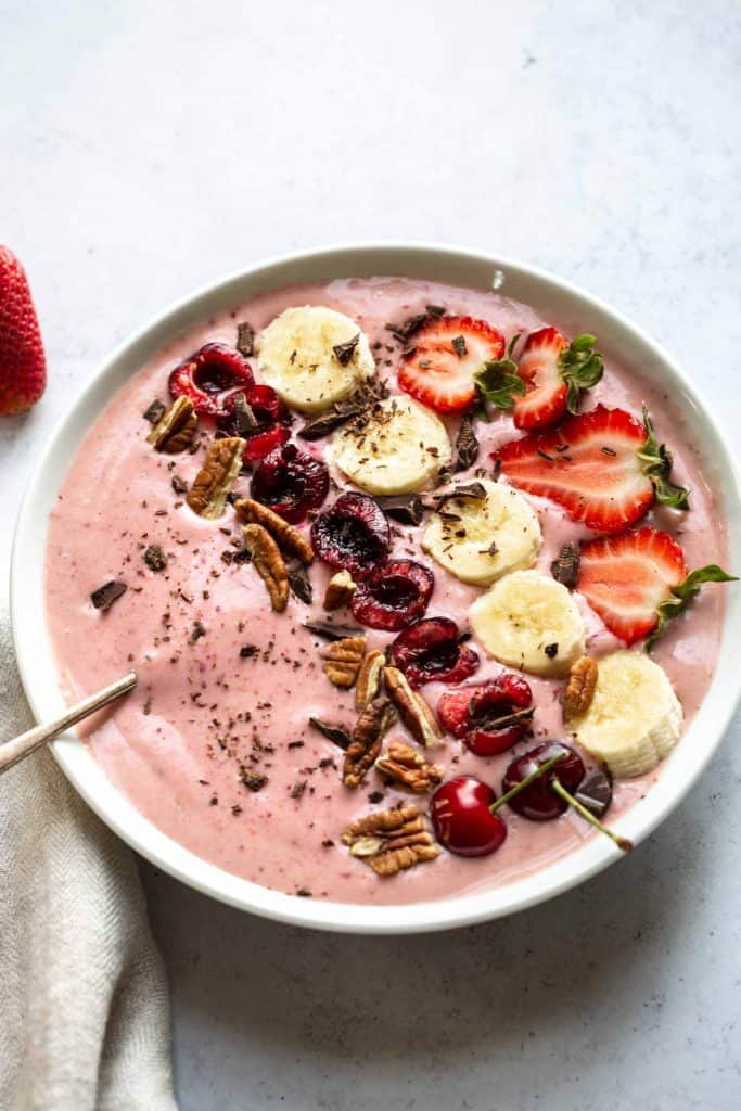 cherry cheesecake smoothie with cherries, bananas and strawberries on top
