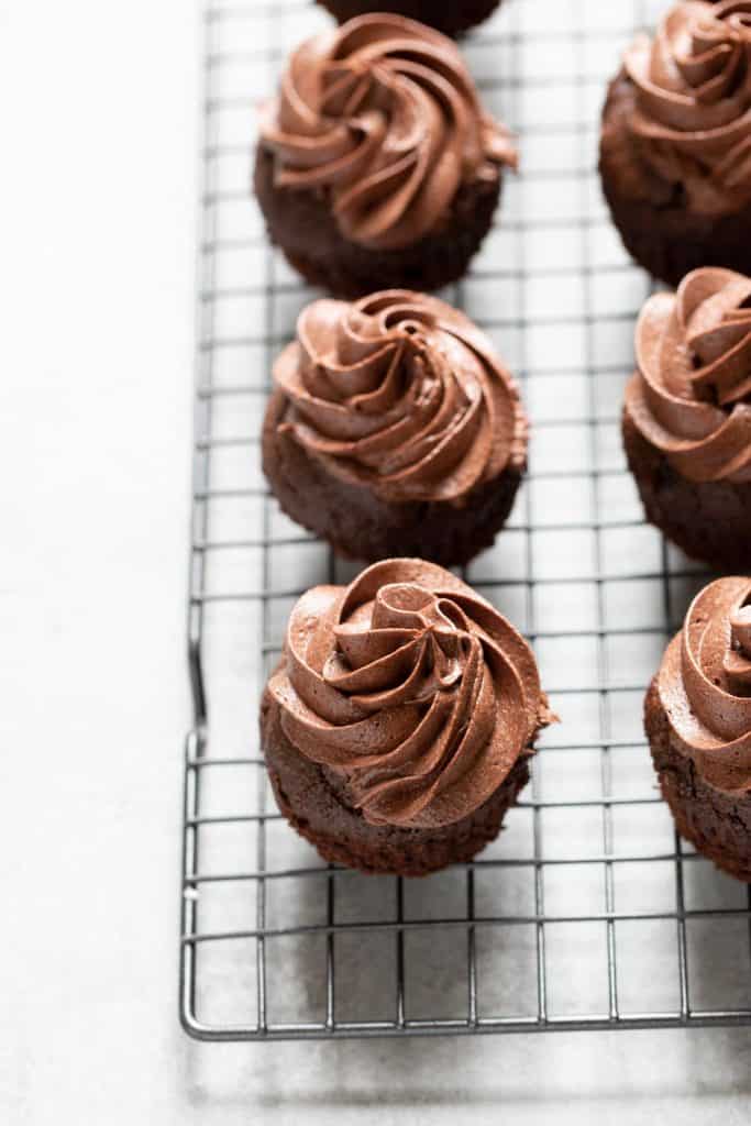 Chocolate cupcakes with frosting piled high.