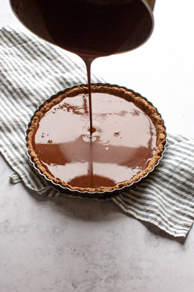 pouring chocolate filling into tart