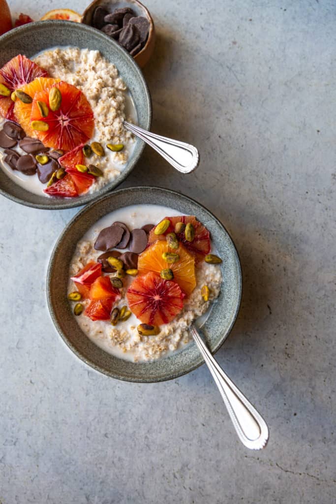 two bowls of oatmeal with blood oranges and chocolate