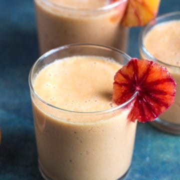 Three glasses of Blood Orange smoothie with a slice of orange.