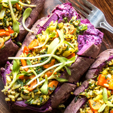 Stuffed sweet potatoes on a wooden plate with a fork - the perfect addition to any portfolio.