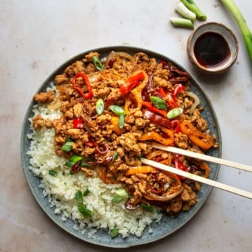 Gluten-free Chinese chicken stir fry on a plate with chopsticks.