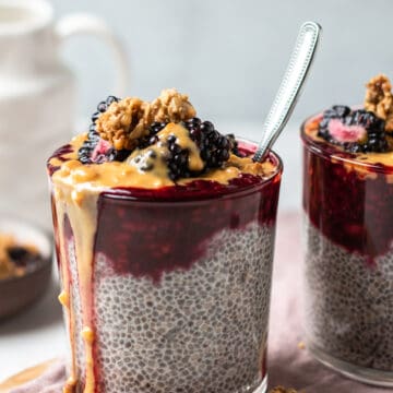 blackberry chia pudding two glasses topped with peanut butter