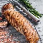 A succulent brown sugar pork tenderloin, seasoned with aromatic spices and herbs, cooked to perfection on a rack.