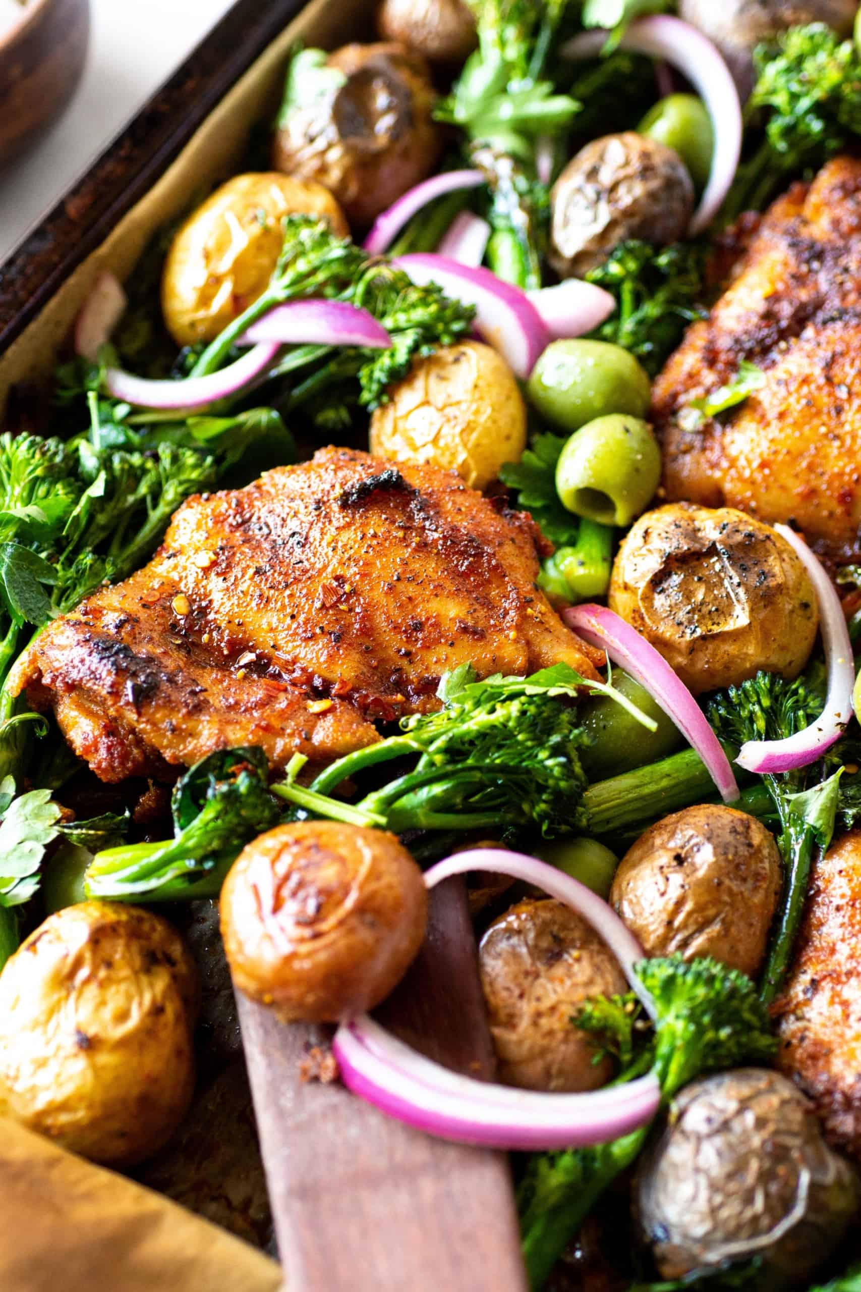 A pan full of gluten-free chicken, potatoes and green onions.