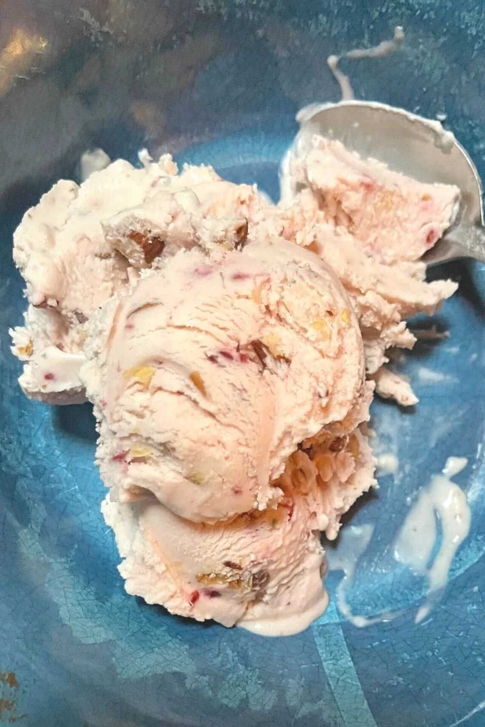 Two scoops of ice cream in a blue bowl.