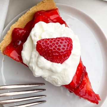 An easy dessert, a slice of strawberry pie with whipped cream and a fork.