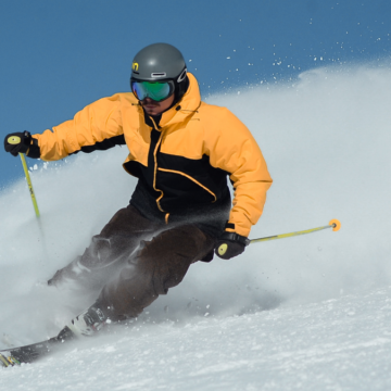 A man enjoying the ID - 10 Adventures of skiing down a snowy slope in Sun Valley.