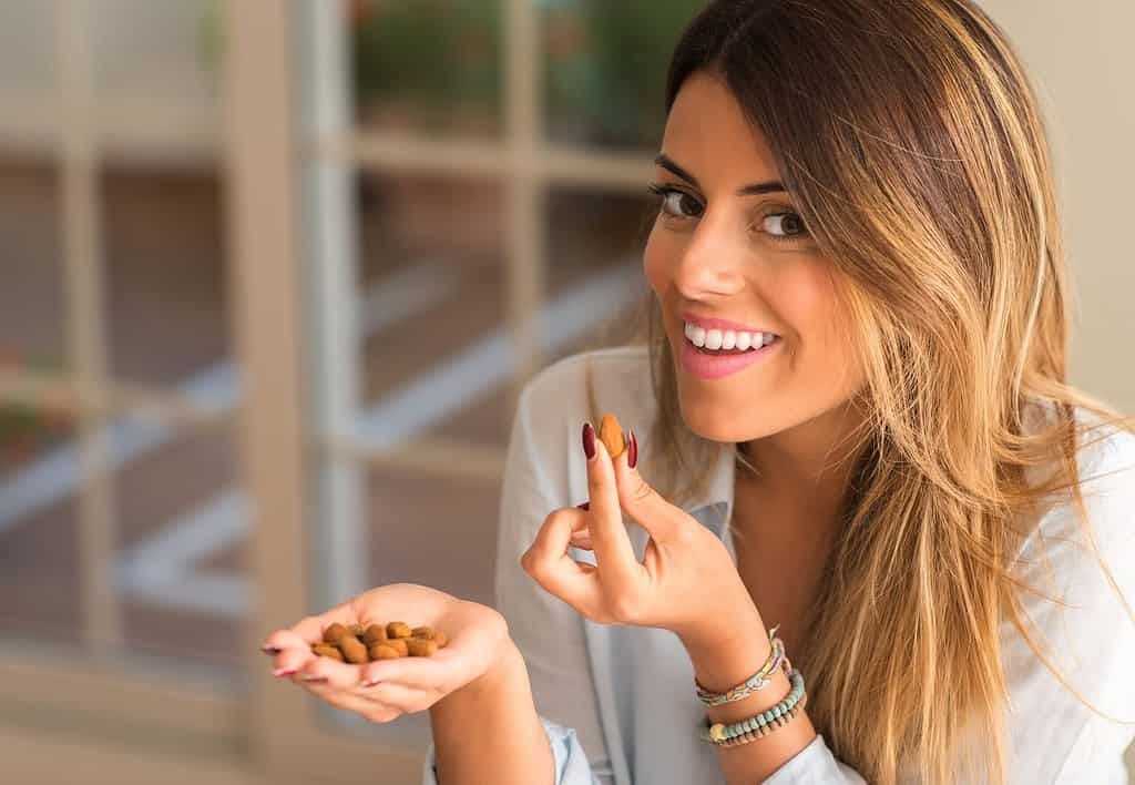 woman eating costco protein snacks almonds