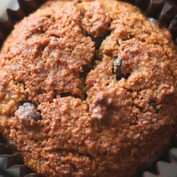Chocolate chip muffins on a cooling rack with almonds and banana recipes.