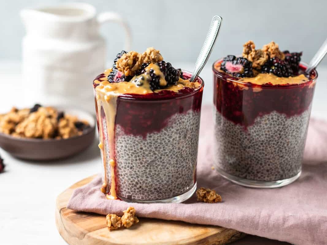 blackberry chia pudding two glasses topped with peanut butter