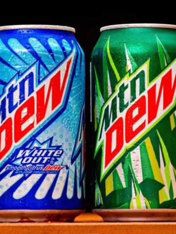 Mountain Dew can splashed with water on black background, product shot