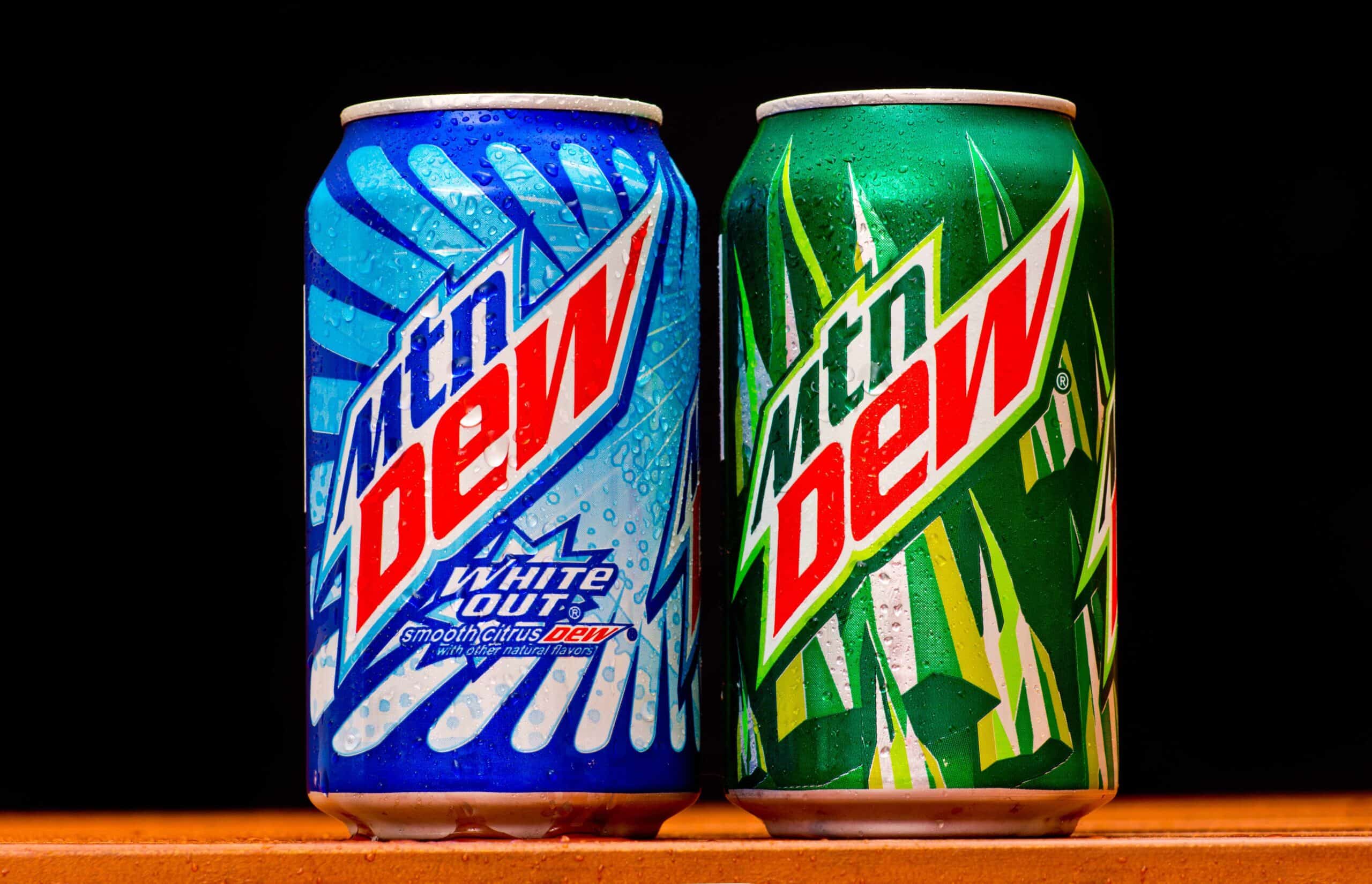    Mountain Dew can splashed with water on black background, product shot