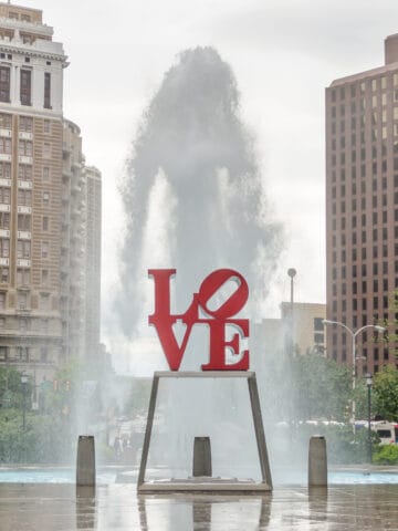 Love Statue in Philadelphia, with scenic fountain against a cloudy sky