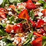 strawberry and pecan salad with feta cheese in a white bowl.
