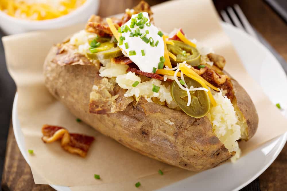 Loaded baked potato with bacon, cheese sour cream and chives