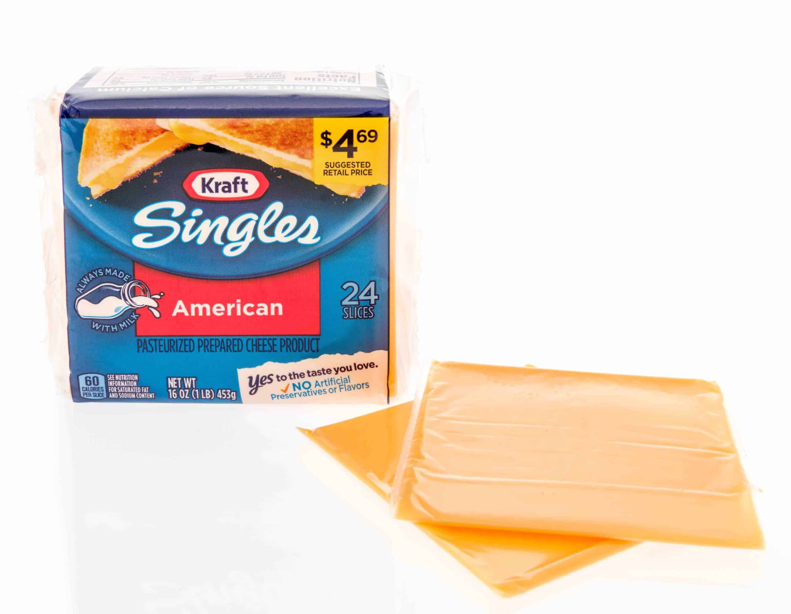  A package of Kraft singles American cheese with cheese slices displayed on an isolated background.