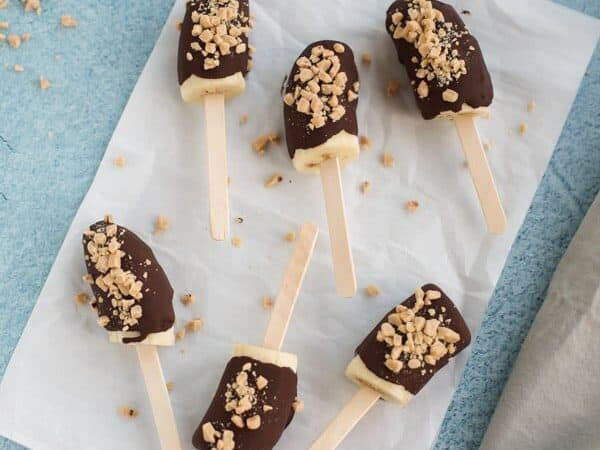 chocolate covered frozen bananas with chopped nuts
