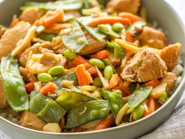 close up of chicken stir fry with snow peas and carrots