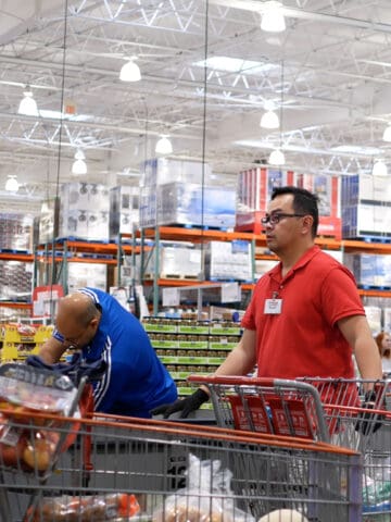 Motion of cashier scanning food and stocking them on trolley at check out counter inside Costco