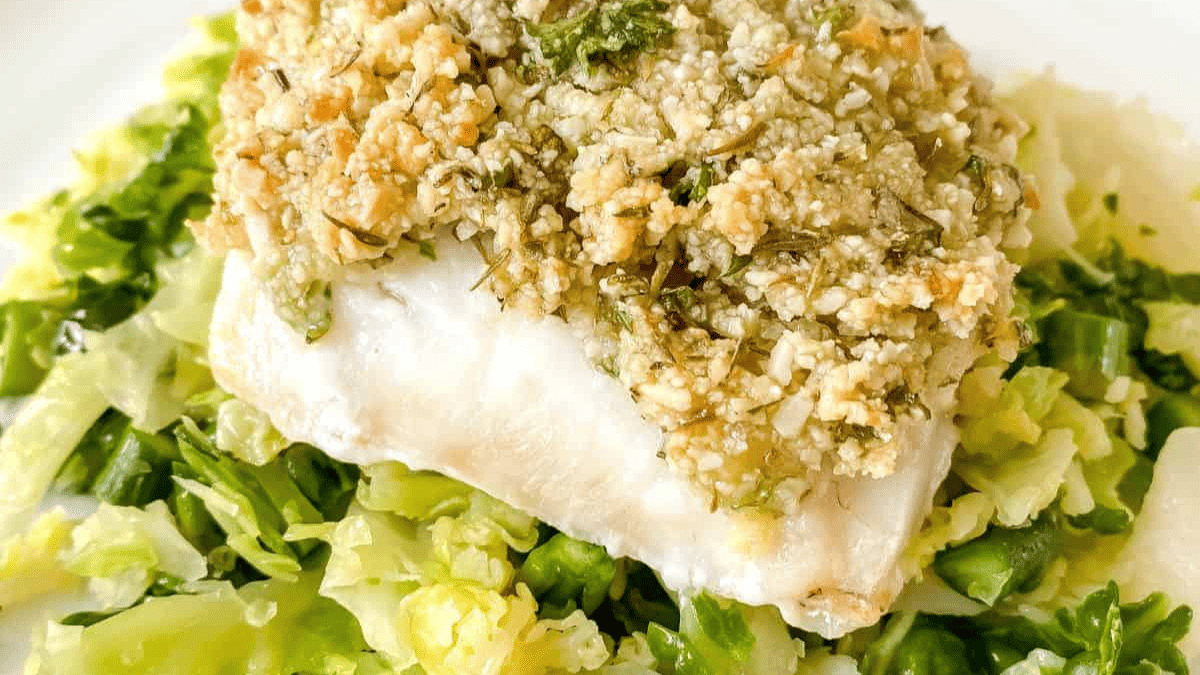  Almond coated cod on a white plate.