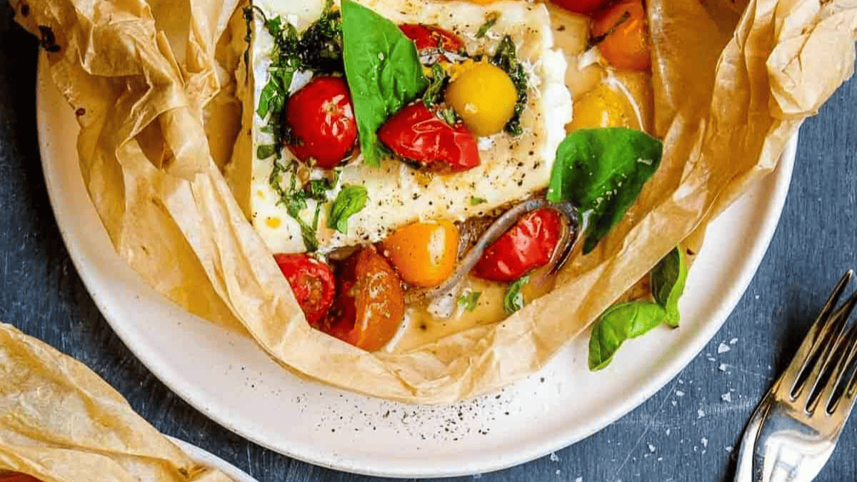A parchment wrapped parcel of cod, baked with herbs and tomatoes.