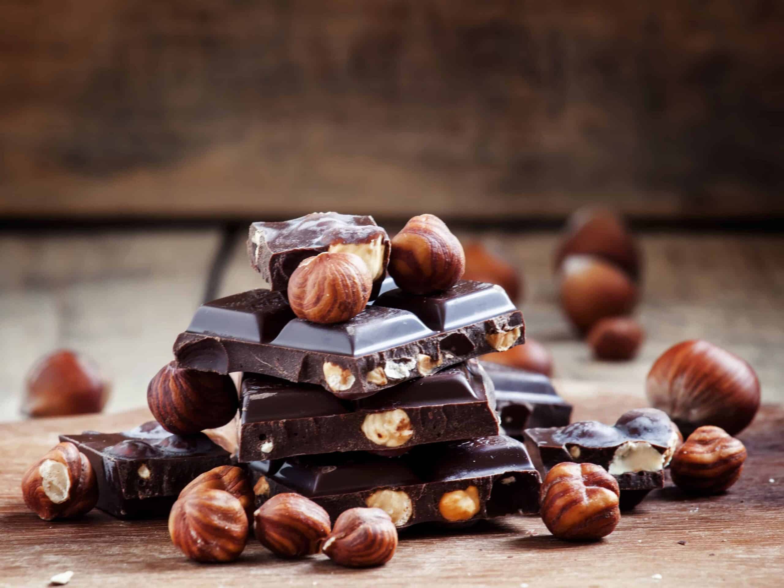 Dark chocolate with hazelnuts on an old wooden background, selective focus