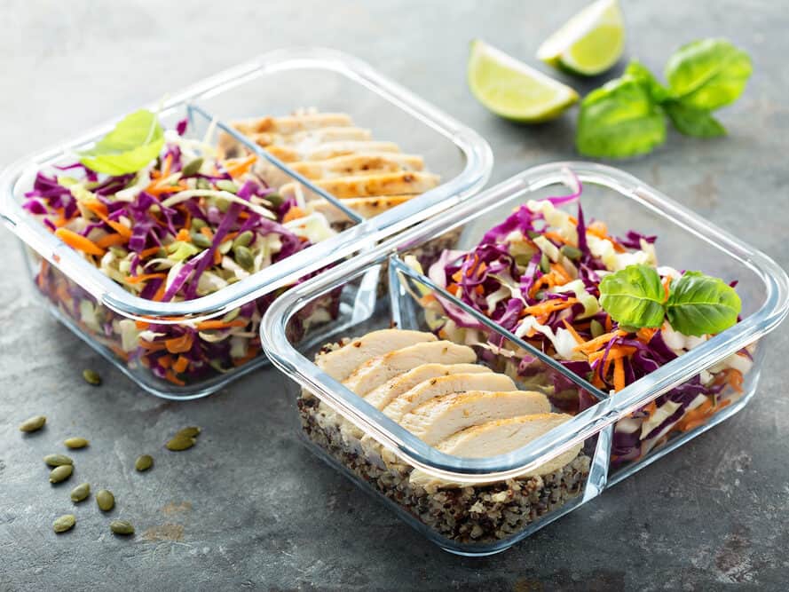 Healthy meal prep containers with quinoa, chicken and cole slaw