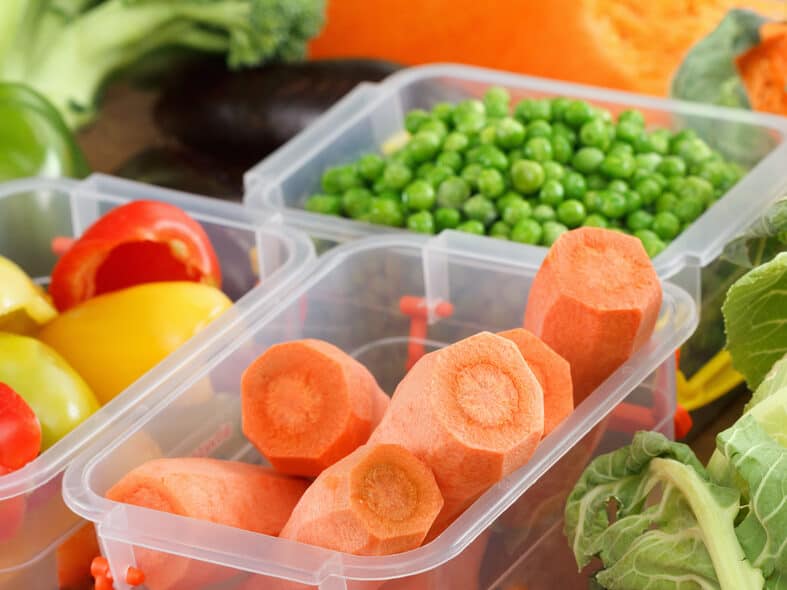 Trays with raw vegetables for freezing. Stocking up for winter storage in plastic containers