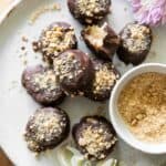 Easy gluten-free chocolate peanut butter balls on a plate with flowers.