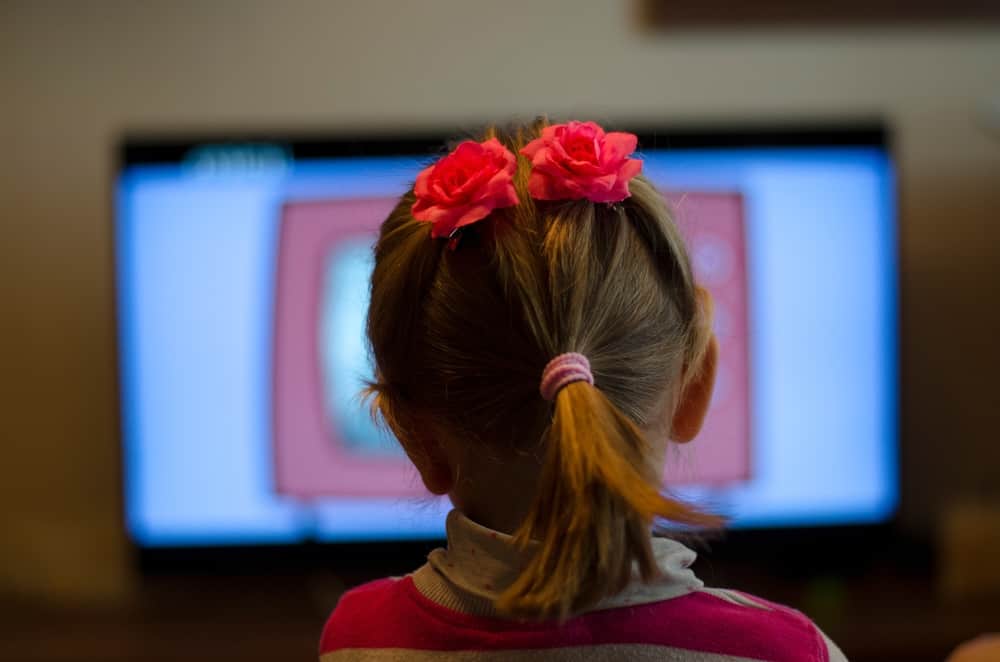 girl sitting too close to tv
