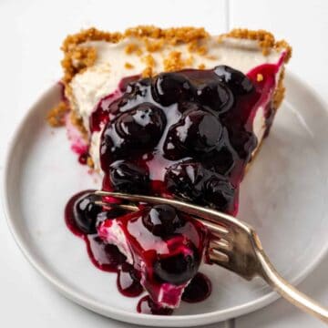 A slice of blueberry pie, one of the 50 easy gluten-free desserts, presented on a plate with a fork.