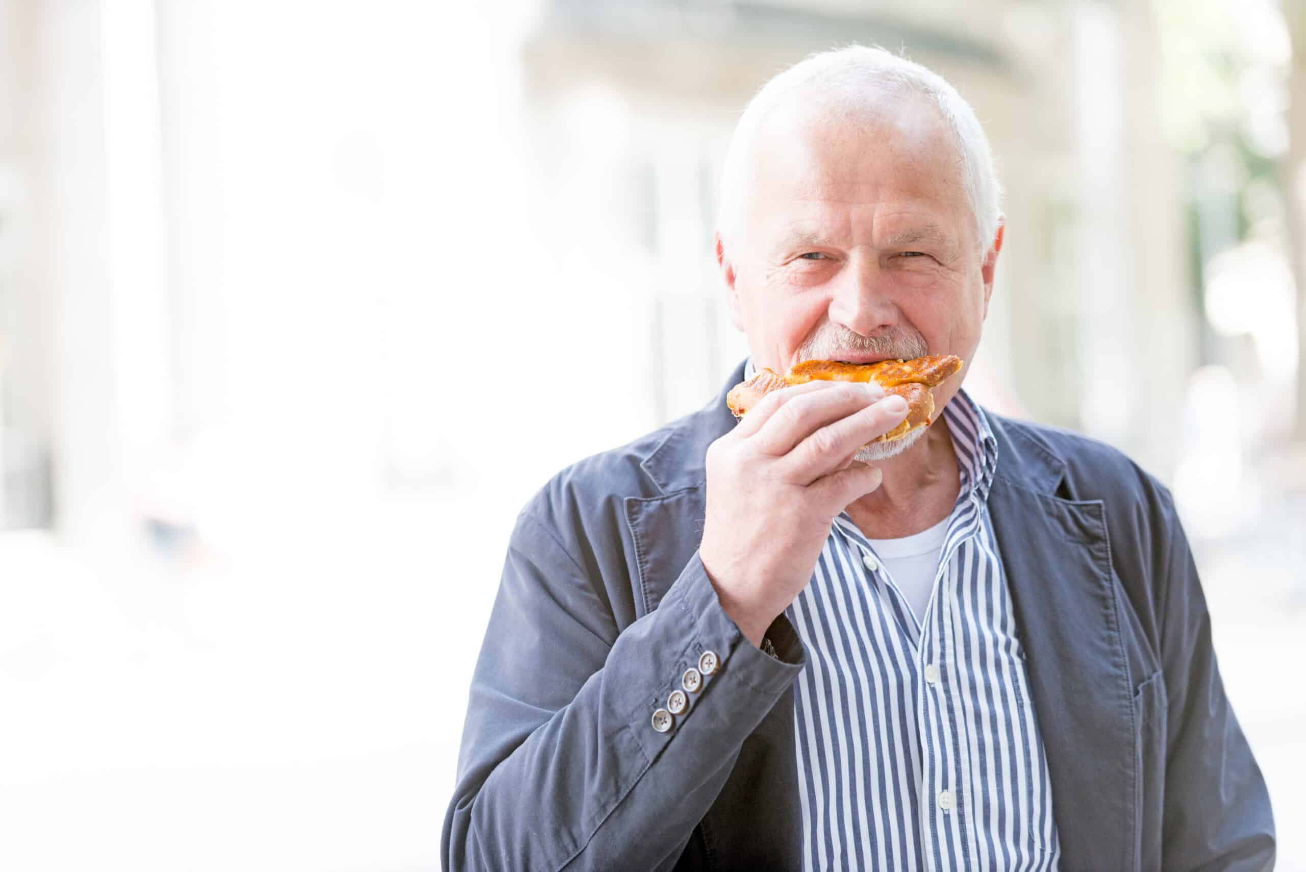 Senior man eats a pizza
